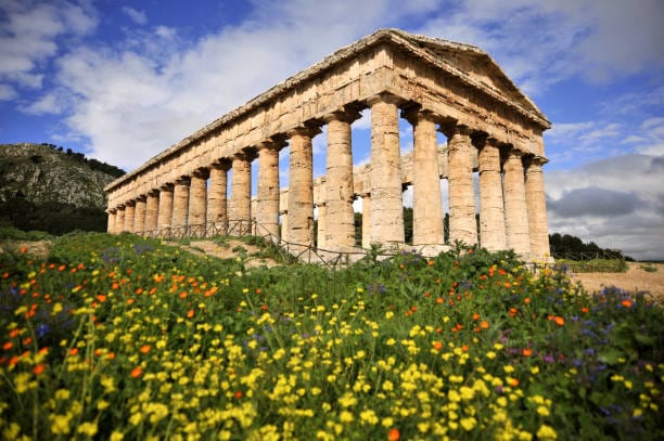 Ruins of Tempio in Segesta Sicily Italy with wildflowers and green grass